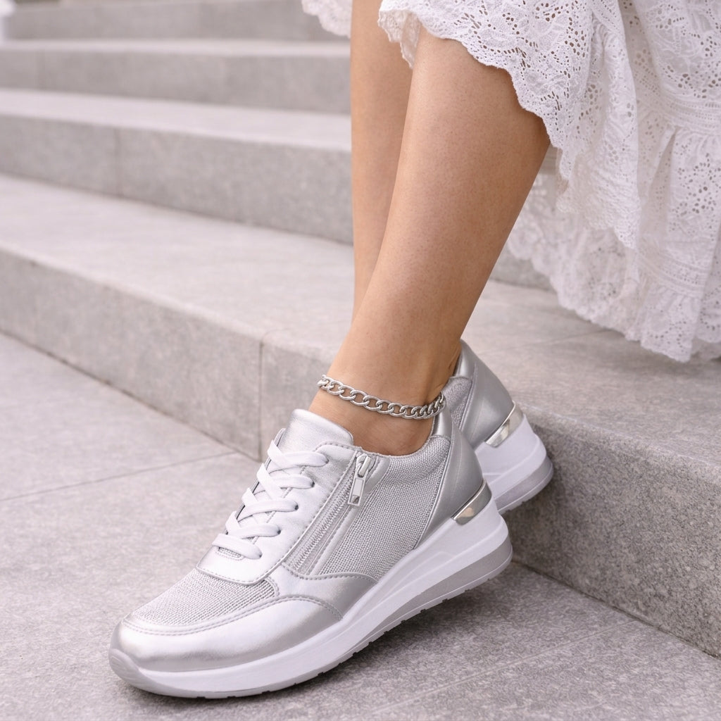 Silver lace up platform sneakers with side zip, worn on stone steps with a white lace skirt