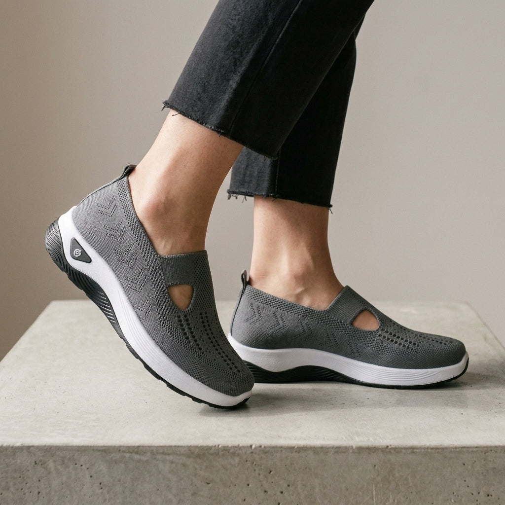 Dark Grey mesh knit sneakers with one foot raised to show the side.