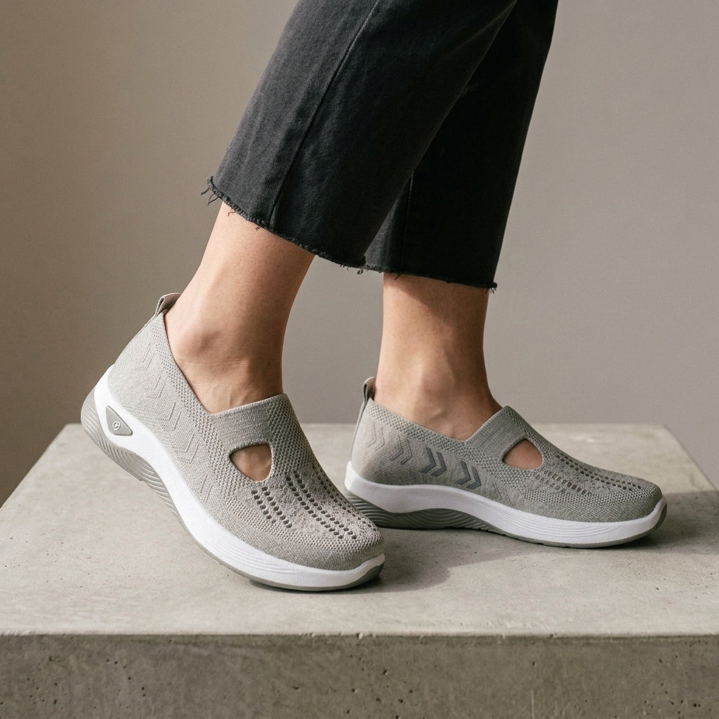 Grey mesh knit sneakers, side view worn with grey frayed jeans.