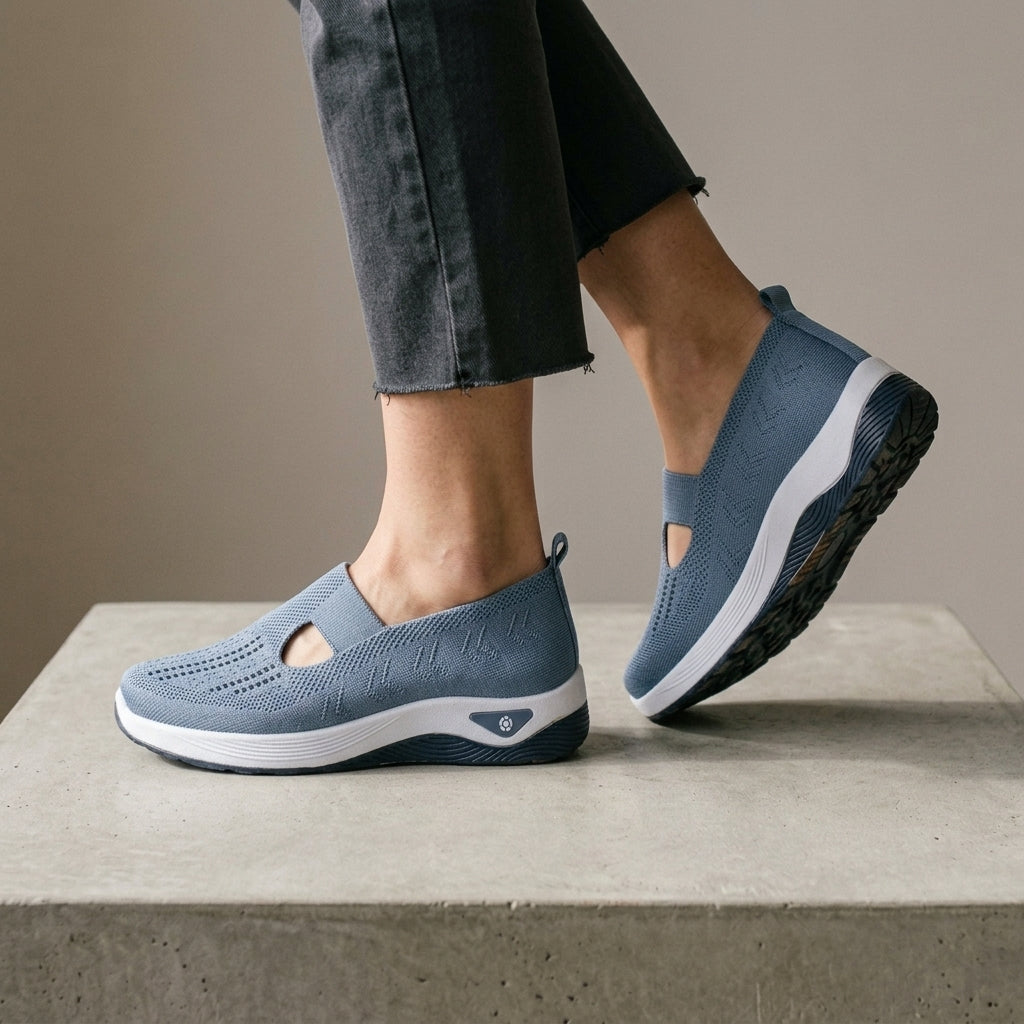 Blue mesh knit sneakers with one foot lifted to show the sole.