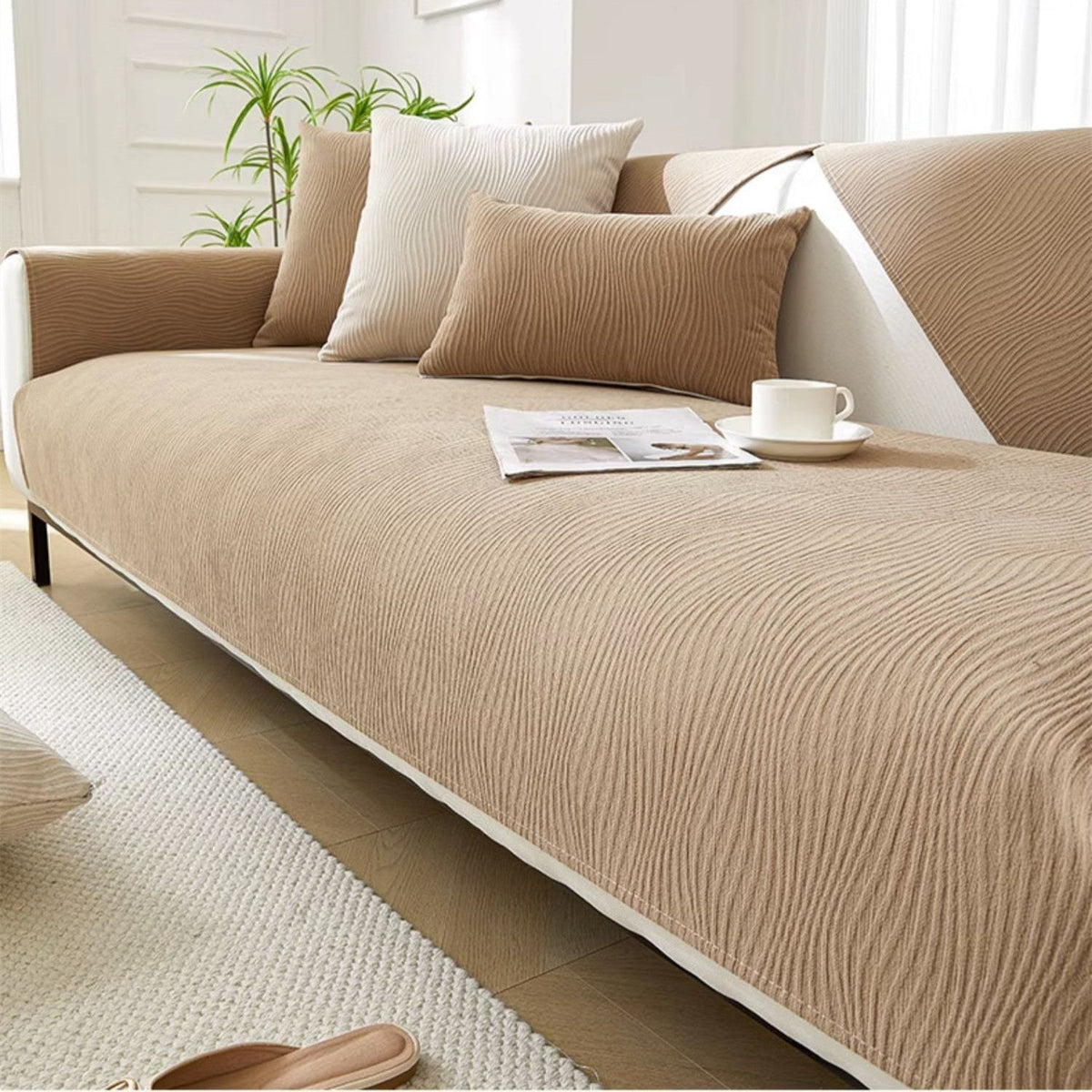 Khaki textured fabric sofa cover on a sofa with a magazine and cup on the seat