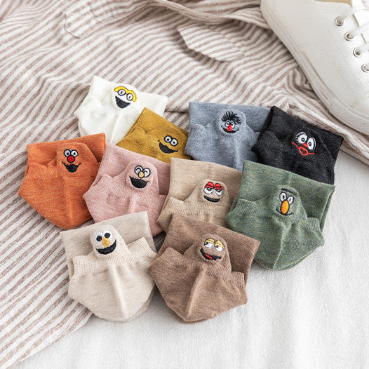 Assortment of low-cut ankle socks in different colours, each with a small embroidered character