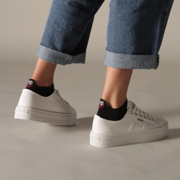 Black ankle socks with embroidered character worn with white platform trainers and rolled-up jeans