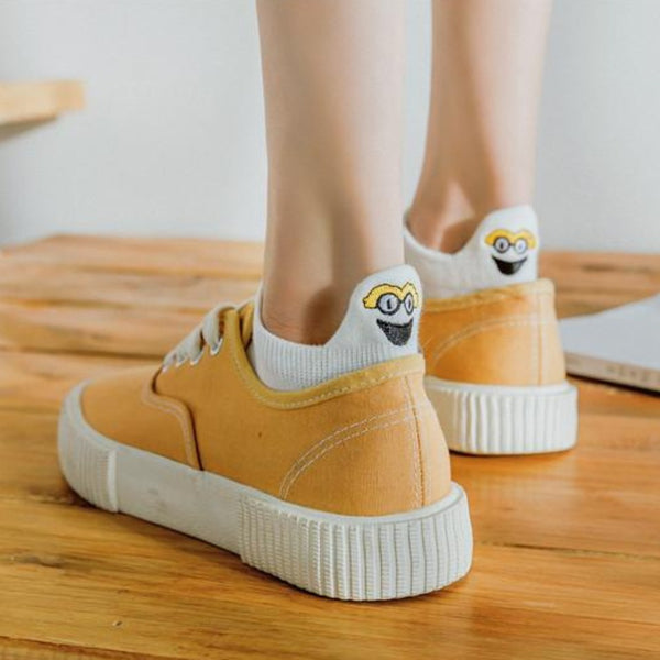 White ankle socks with embroidered character worn with mustard canvas trainers