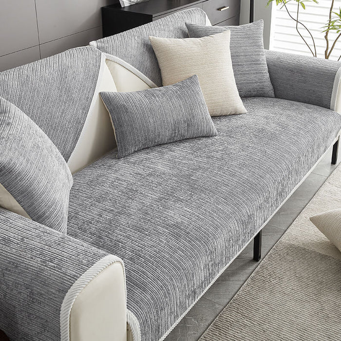 Light grey woven fabric sofa cover over a sofa seat, backrest and armrest with matching cushion covers