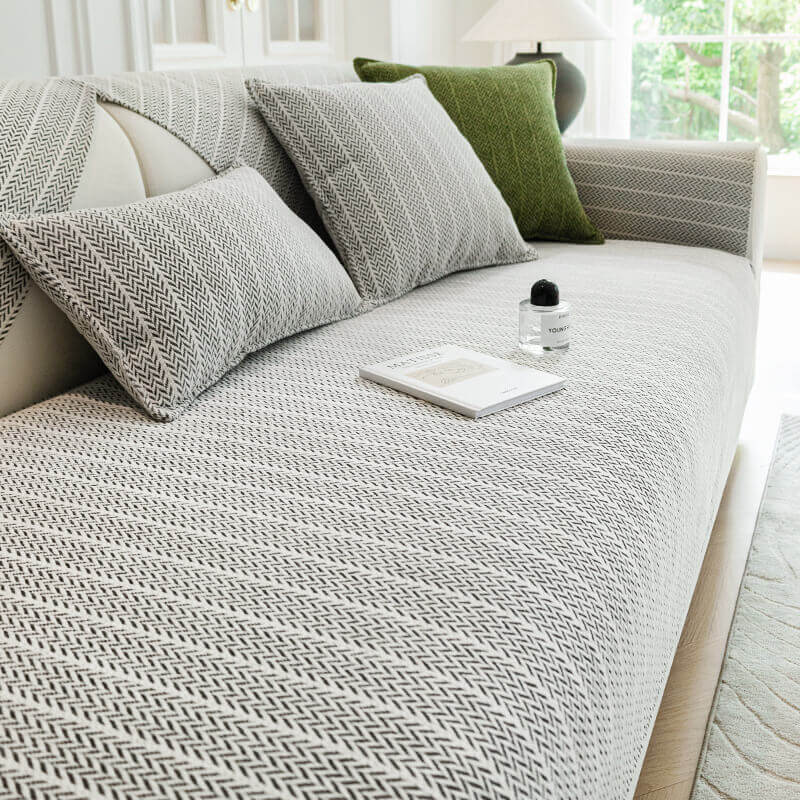 Light grey herringbone sofa cover on a cream sofa with matching cushions