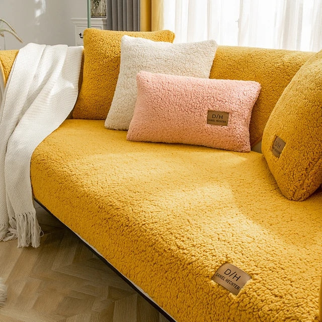 Yellow teddy fleece sofa cover with cushion covers and a knitted throw on the sofa arm