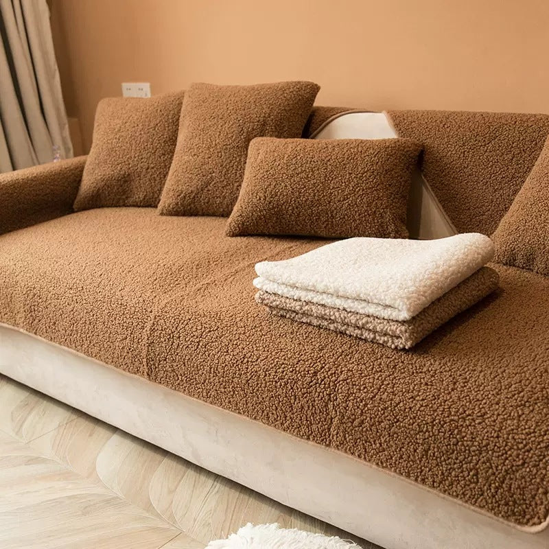 Brown plush teddy sofa cover with folded teddy throws on the seat
