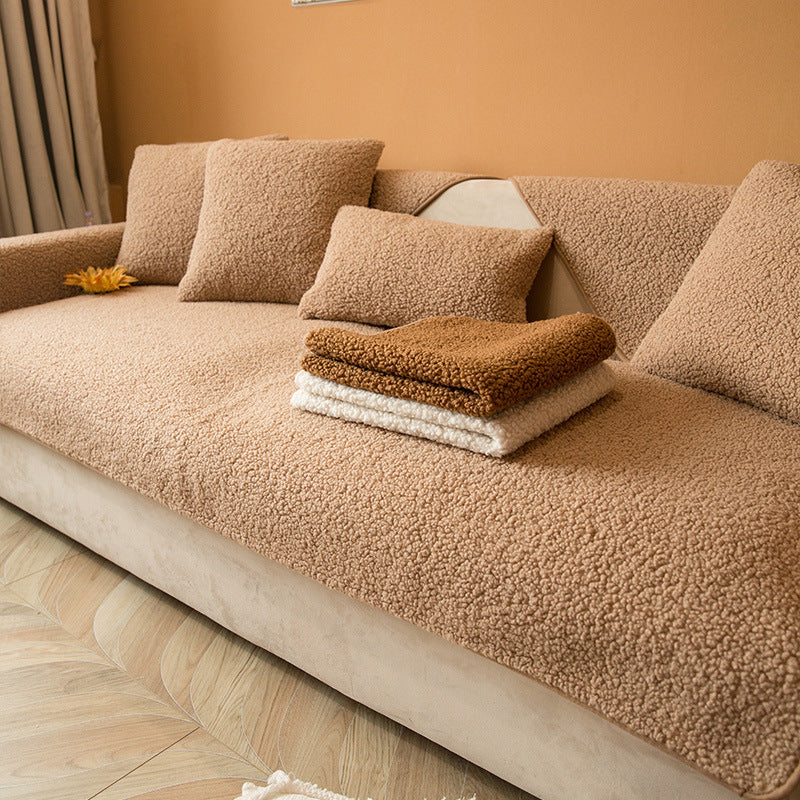 Light brown plush teddy sofa cover with folded throws on the seat