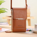 Brown crossbody phone bag with adjustable strap on a styled table