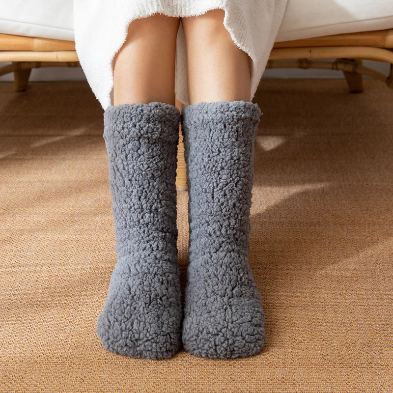 Grey fluffy teddy fleece mid-calf socks worn on a woven rug