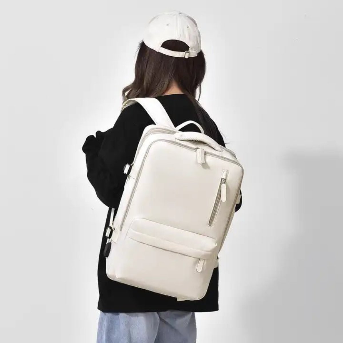 Person wearing beige multi-compartment backpack, rear view