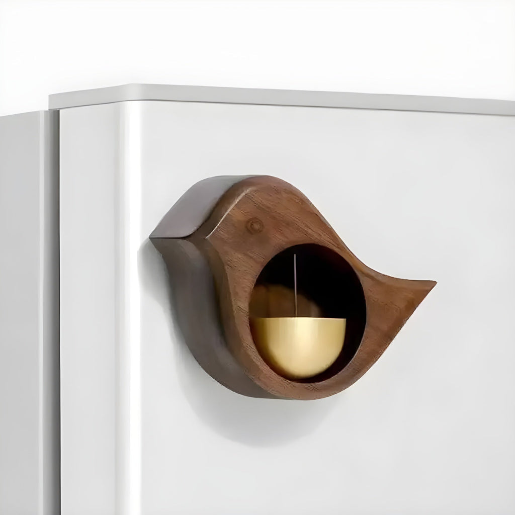 Wood-effect bird door bell with gold-tone bell fitted to a white surface