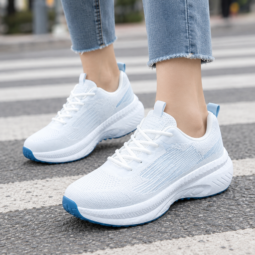 Lace up sneakers for women in white mesh knit with light blue accents, chunky white platform sole and blue outsole, worn with frayed light jeans