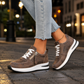 Women's platform trainers in brown with side zip trainers detail, white laces and chunky white sole, worn with cropped jeans