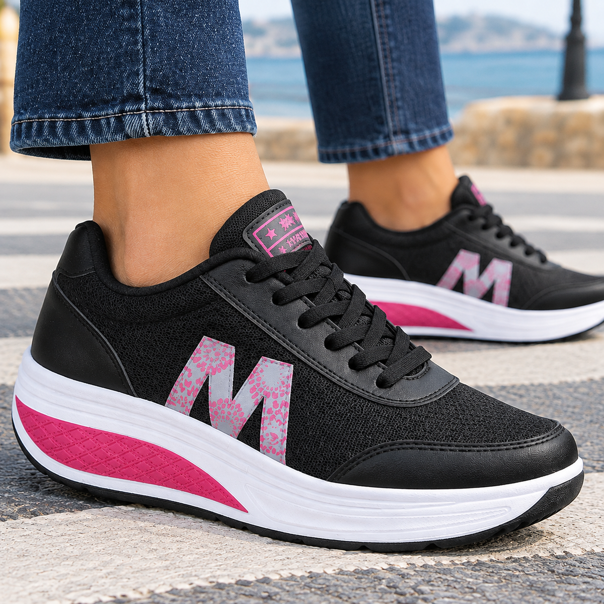 Close-up of black mesh sneakers on foot, showing the breathable upper, lace-up closure and rocker platform sole.