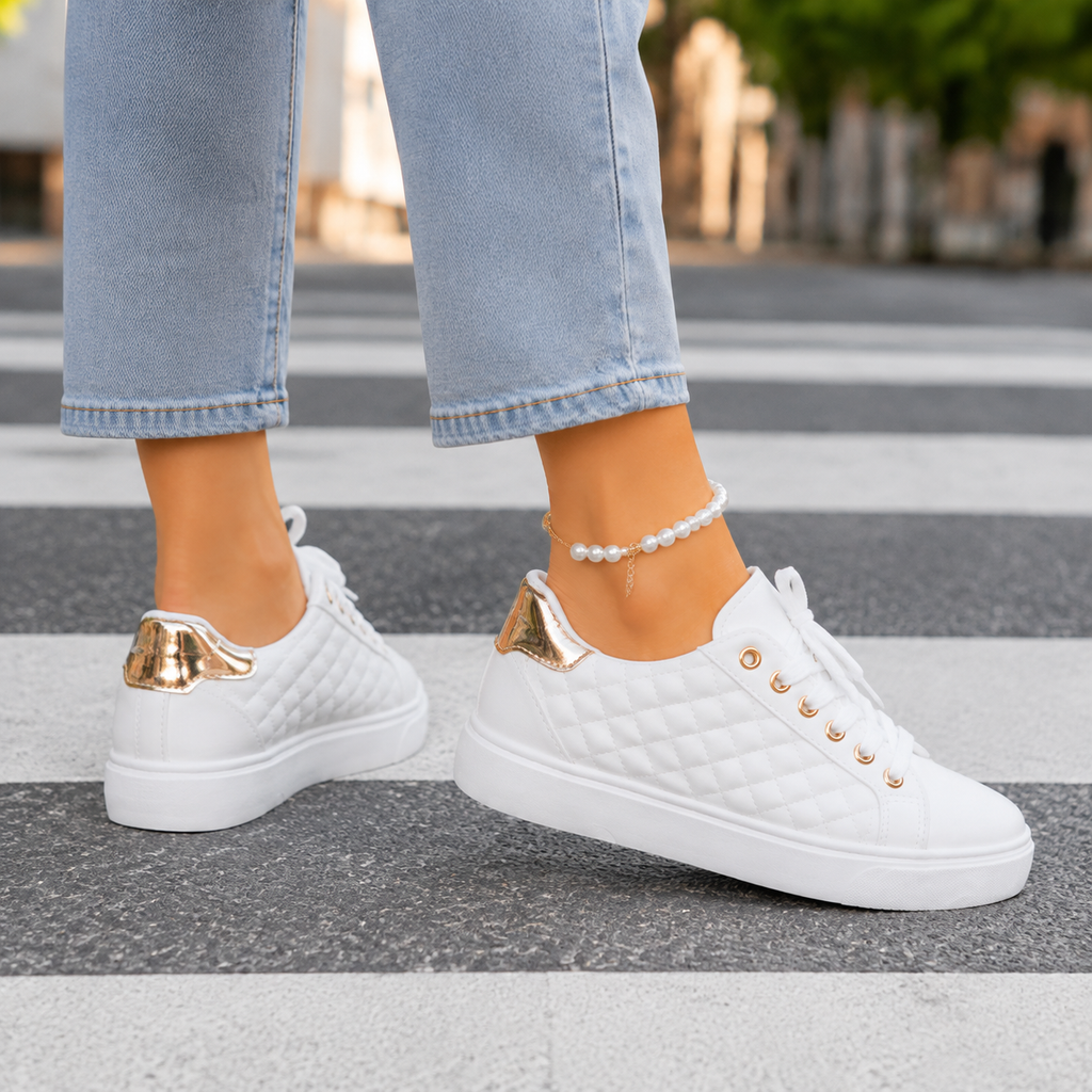 White quilted platform trainers with gold-tone eyelets, shown from the side and back