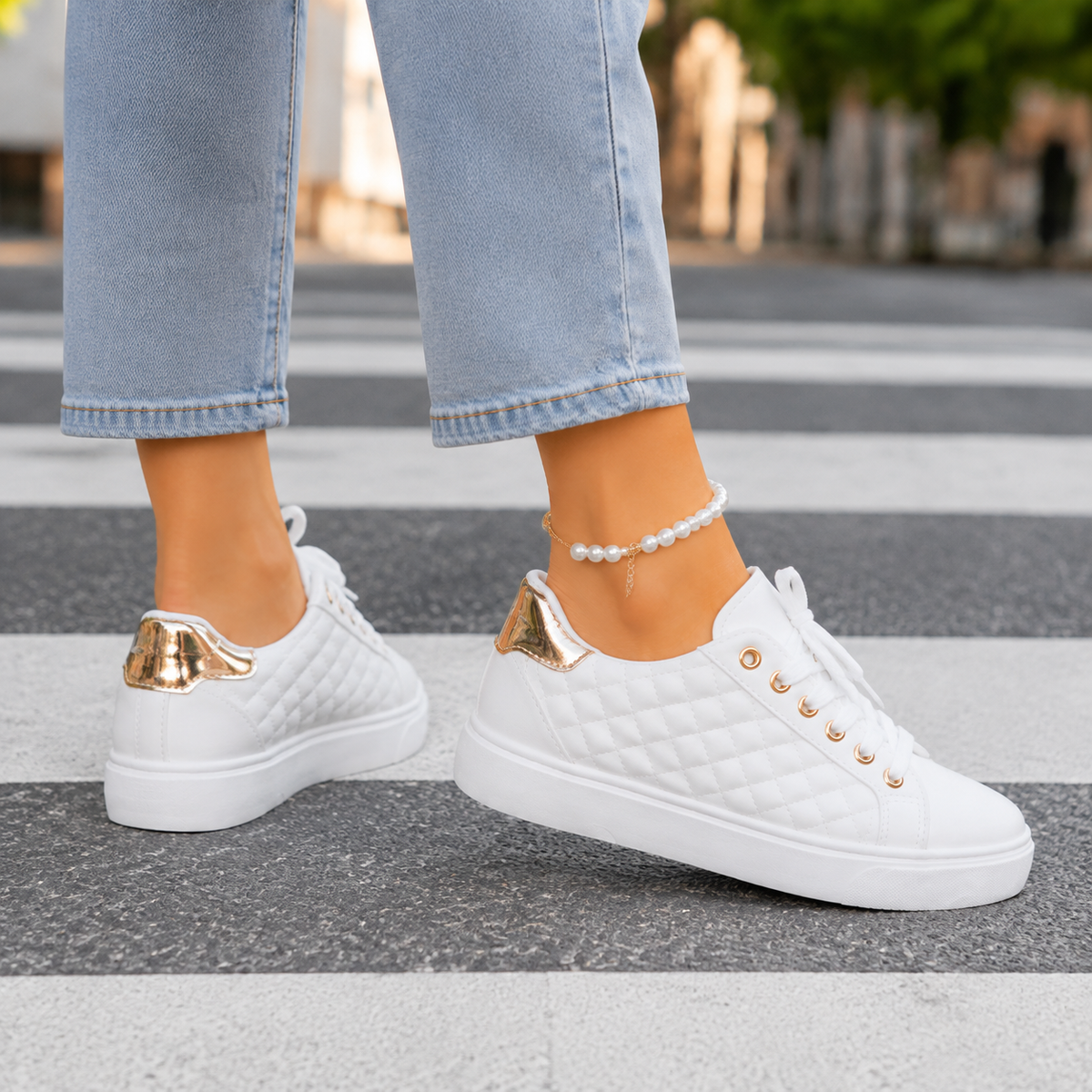 White quilted platform trainers with gold-tone eyelets, shown from the side and back