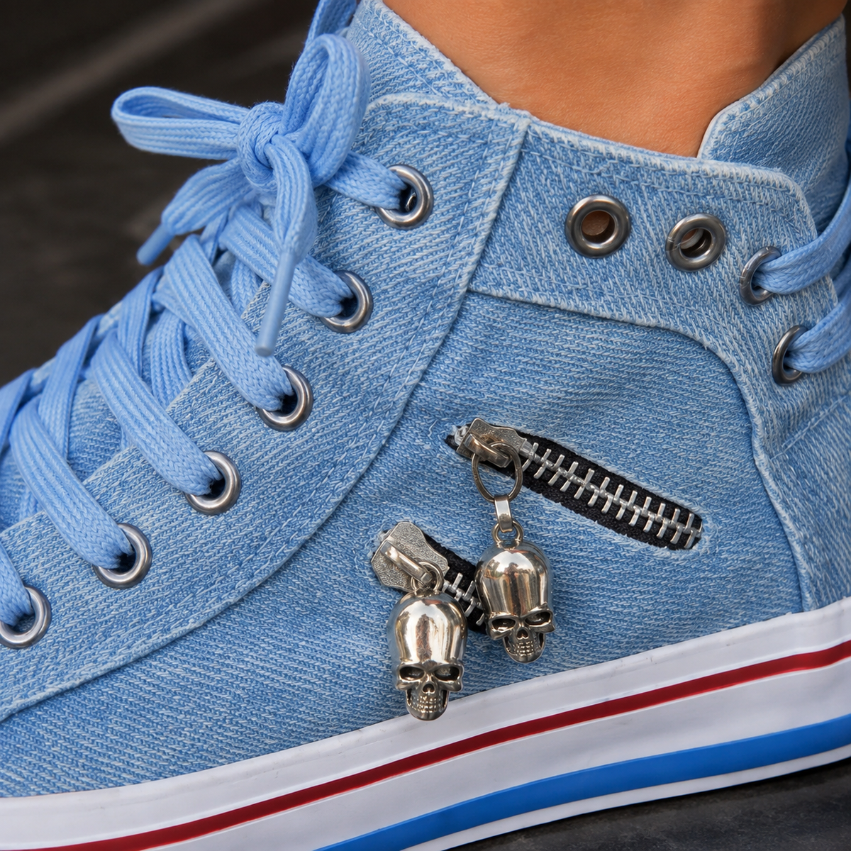 Close-up of side zip and skull-shaped metal charms on blue high top sneakers