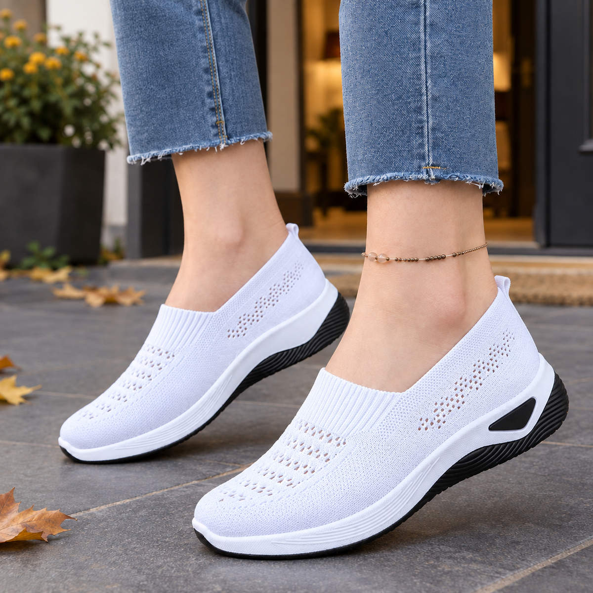 White breathable knit slip-on sneakers with ventilated open-knit panels and a low raised sole