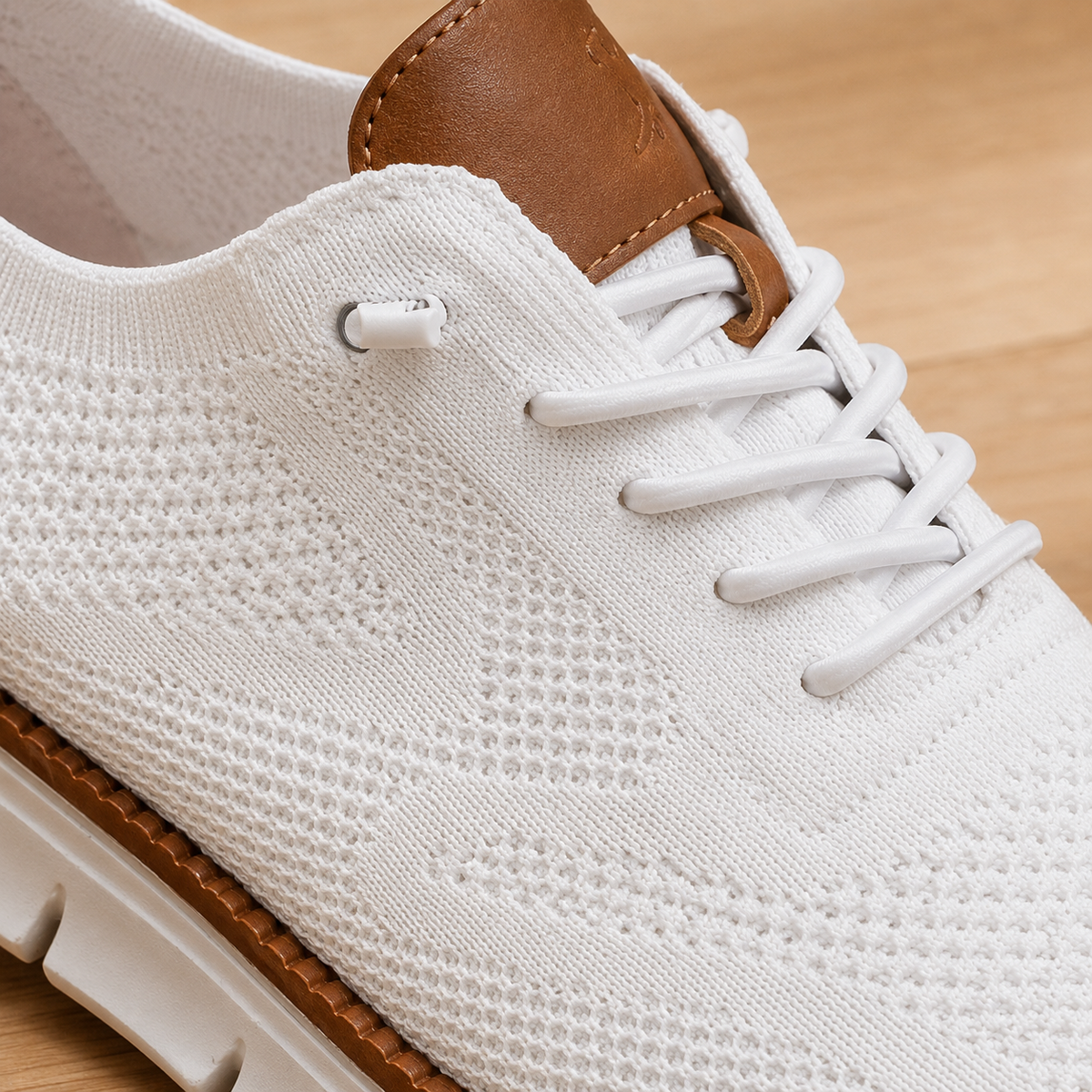 Close-up of the white knit upper and elastic laces of the sneaker