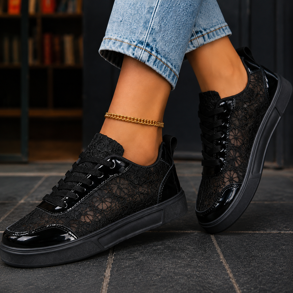 Black floral lace trainers with glossy toe cap and lace-up front, worn with jeans