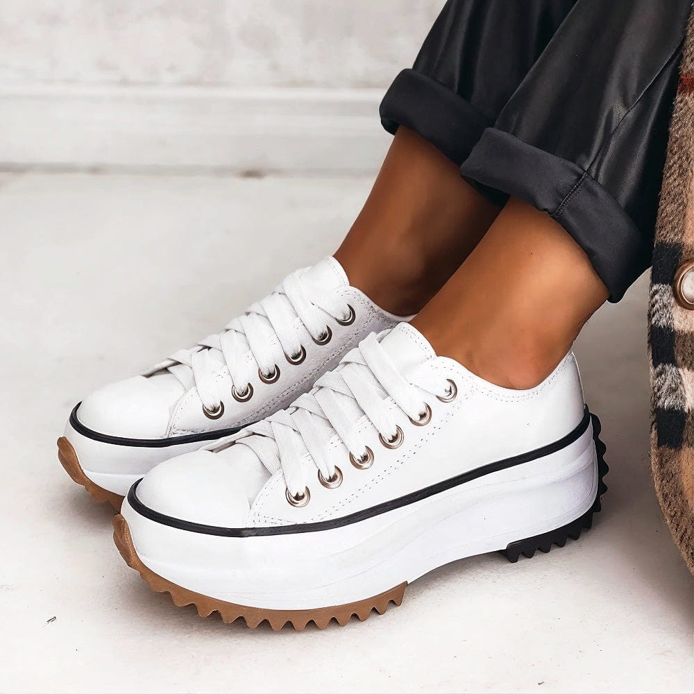 White lace-up platform trainers with a black stripe and chunky sole